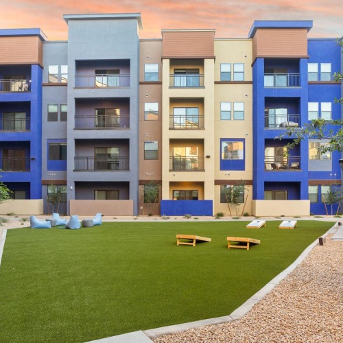 a courtyard with a few tables and chairs in front of a building