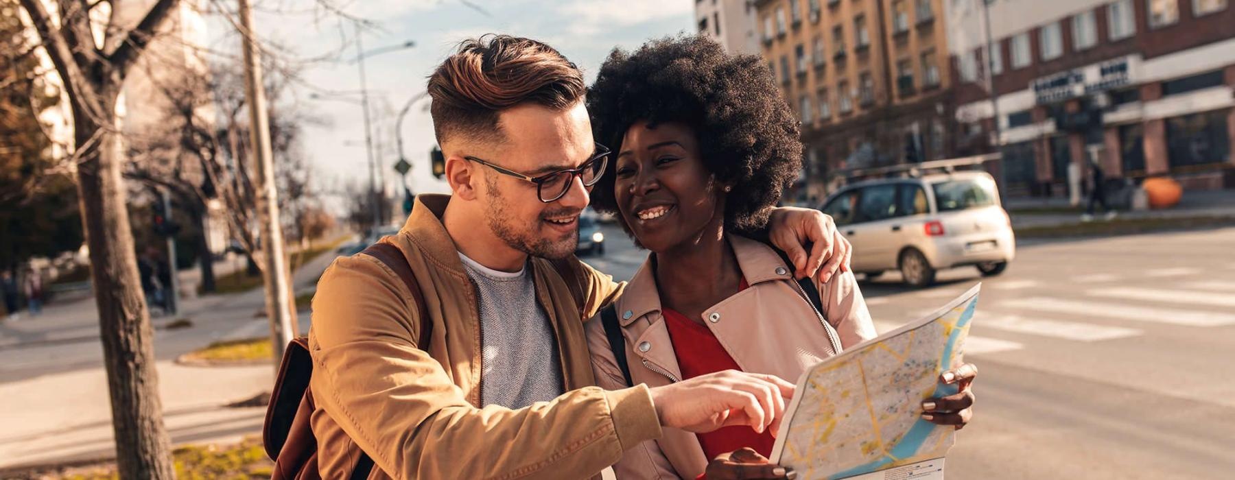 a man and woman looking at a map in the city